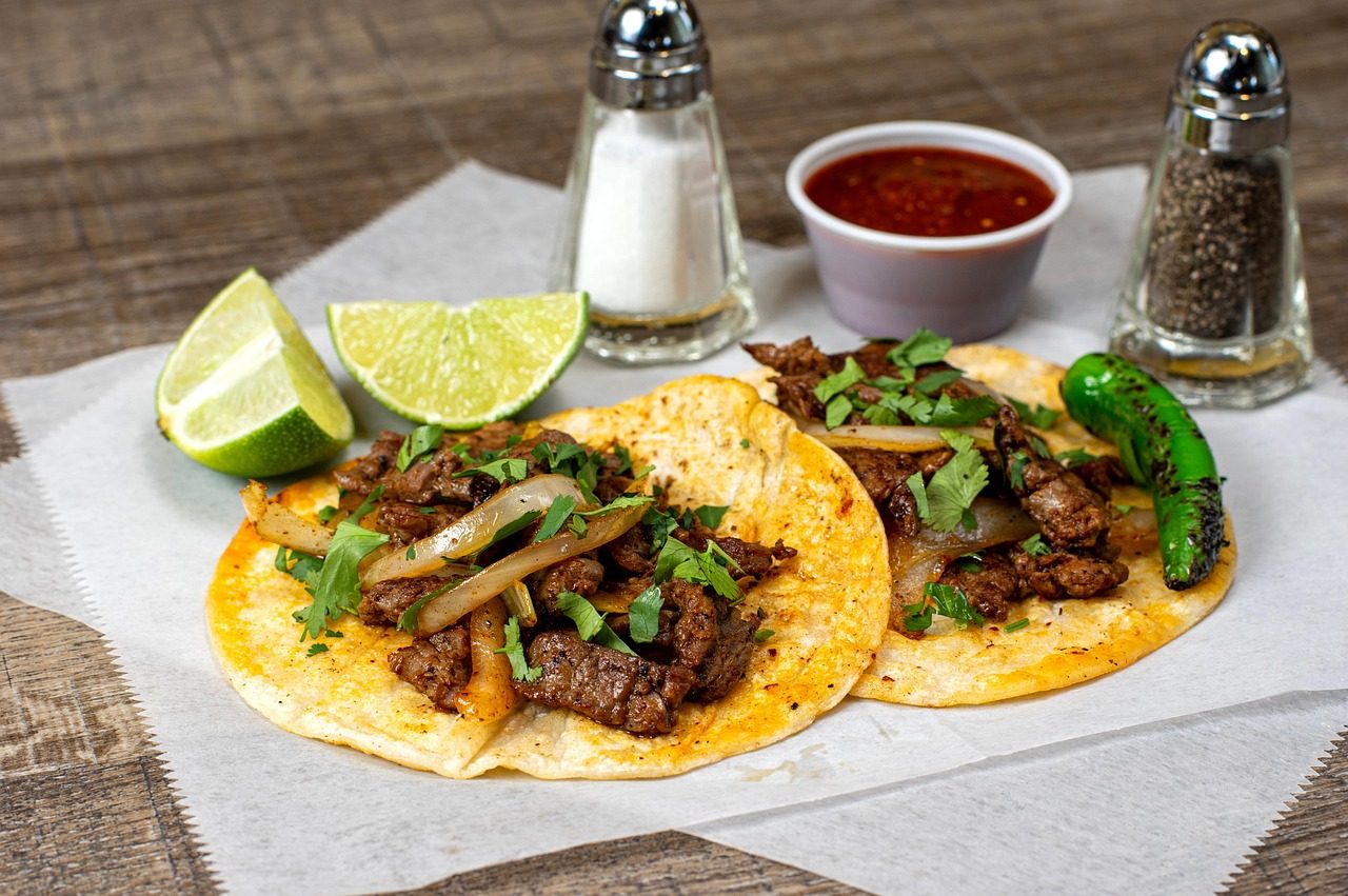 Beef tacos on corn tortillas with lime, cilantro, onion and salsa